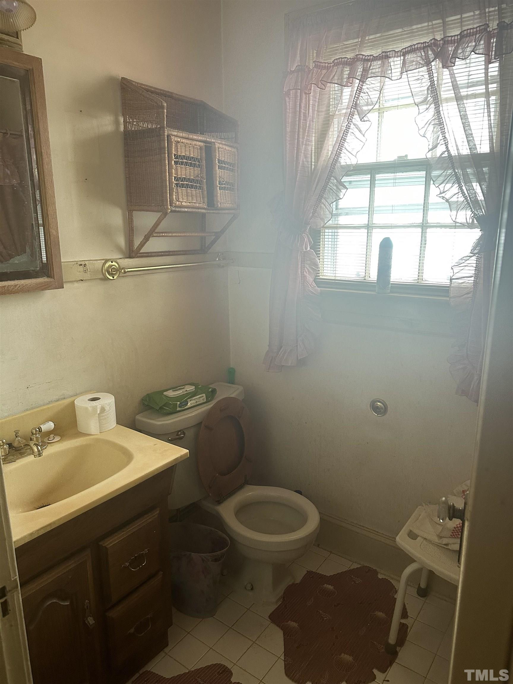 1309 Canterbury Road Raleigh, NC 27607 - Photo 14 of 32 a bathroom with a sink a toilet and a window