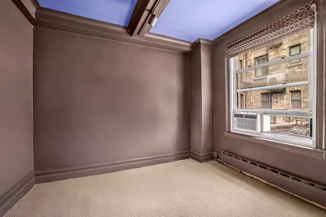 a view of an empty room with a window and closet