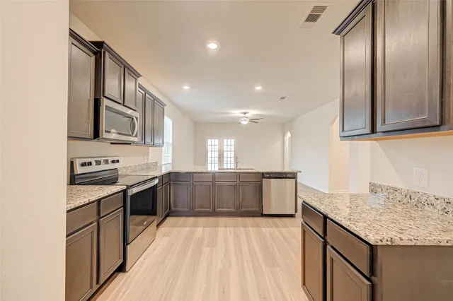a kitchen with stainless steel appliances granite countertop a sink stove and cabinets