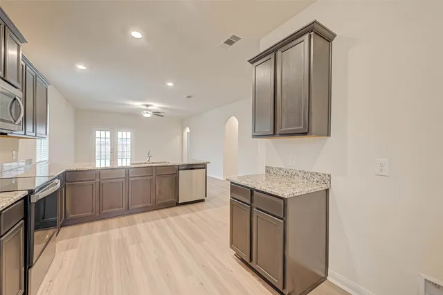a kitchen with granite countertop cabinets stainless steel appliances and a sink