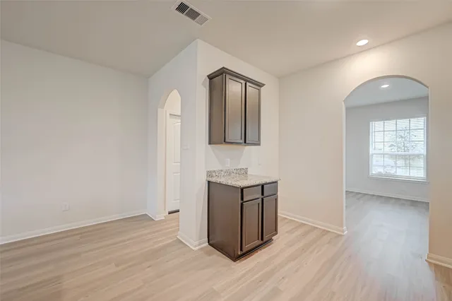a kitchen with granite countertop a stove top oven sink and cabinets