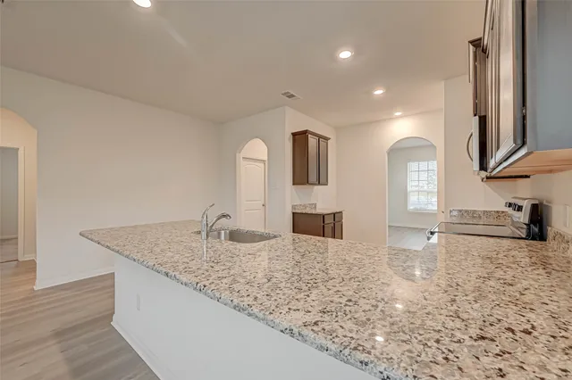 a kitchen with kitchen island granite countertop counter top space cabinets and stainless steel appliances