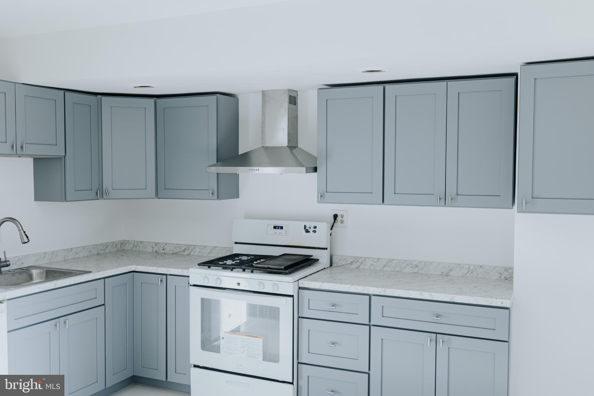 2511 Madison Avenue, Unit 3 Baltimore, MD 21217 - Photo 5 of 12 a kitchen with granite countertop white cabinets and white appliances