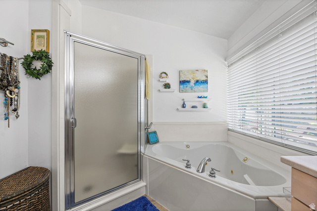 31 Village Square Road Centerville, UT 84014 - Photo 10 of 29 Bathroom featuring a shower enclosure with a frosted glass door, an integrated jetted tub with polished chrome fixtures, white window blinds, and white wall shelving