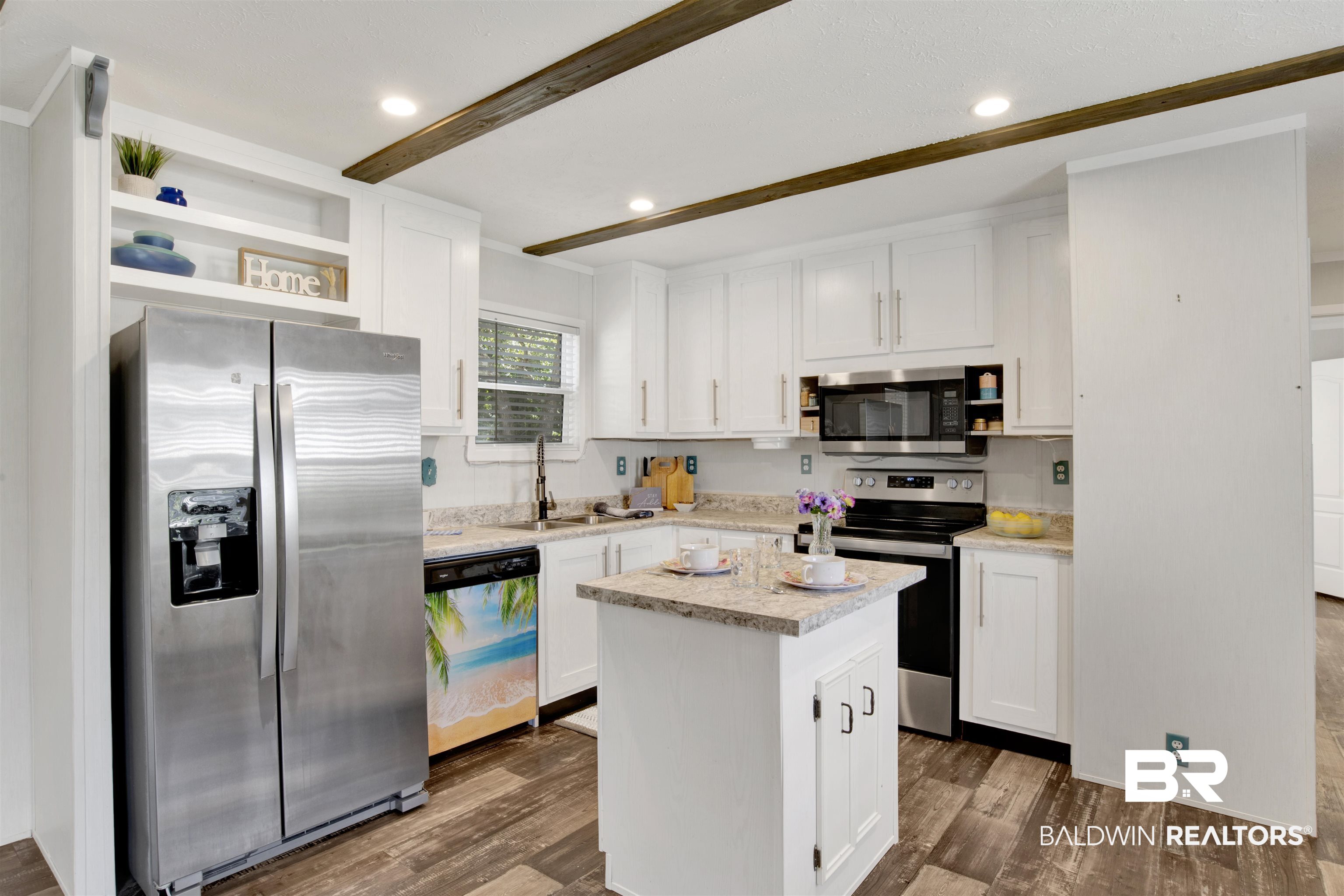 1411 Ridgewood Drive Lillian, AL 36549 - Photo 15 of 30 Kitchen with stainless steel appliances, white cabinetry, dark hardwood / wood-style flooring, and a kitchen island