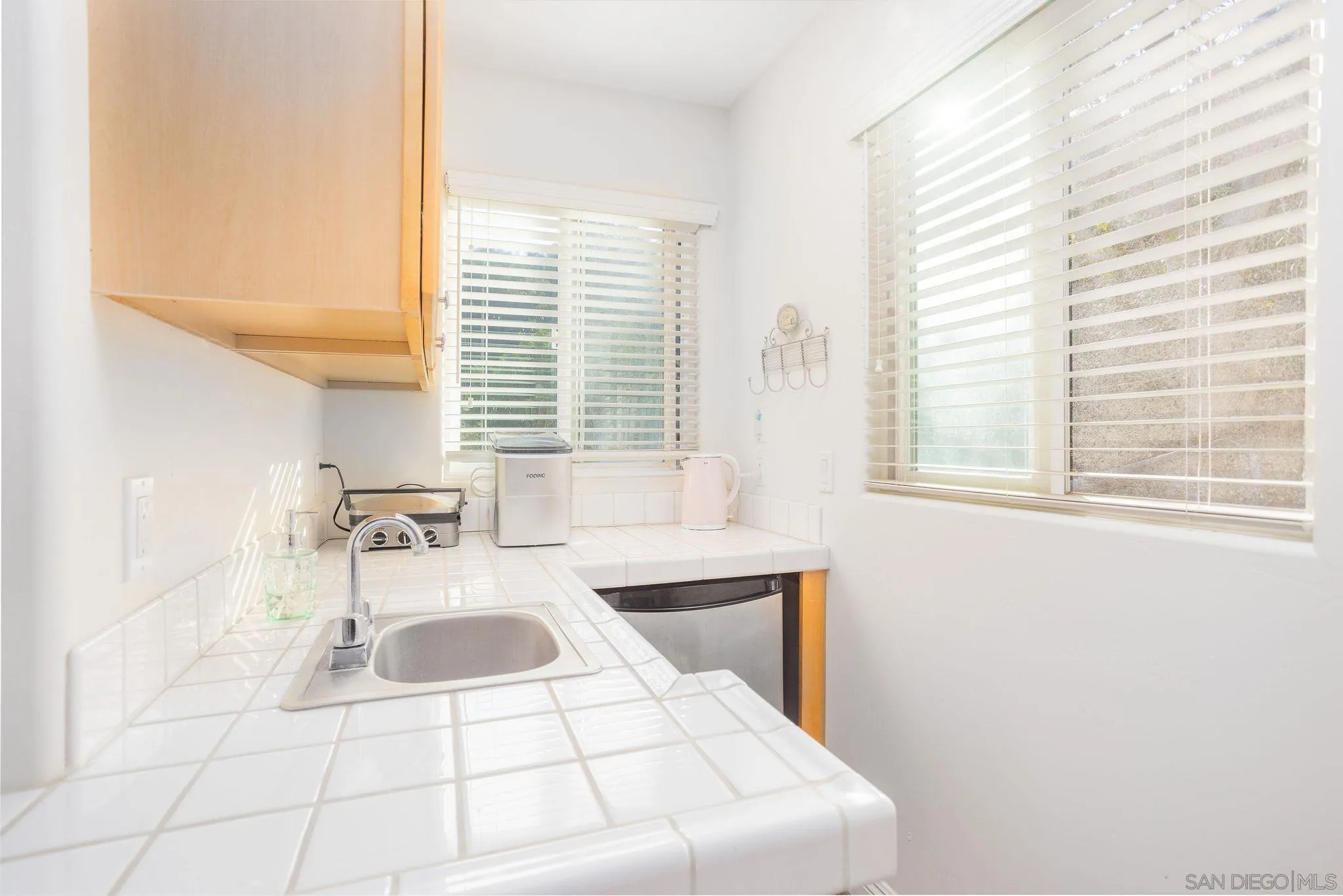 4003 Millagra Drive Fallbrook, CA 92028 - Photo 33 of 46 a kitchen with a sink a stove a white cabinet a mirror and a window