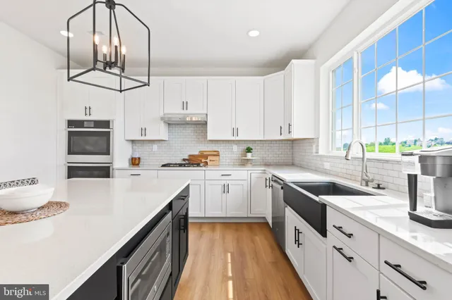 a kitchen with kitchen island granite countertop a sink a counter space appliances and cabinets
