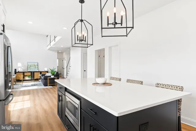 a open dining room with stainless steel appliances kitchen island a table chairs and a kitchen view
