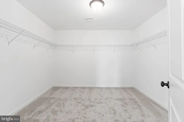 an empty room with a window and a ceiling fan