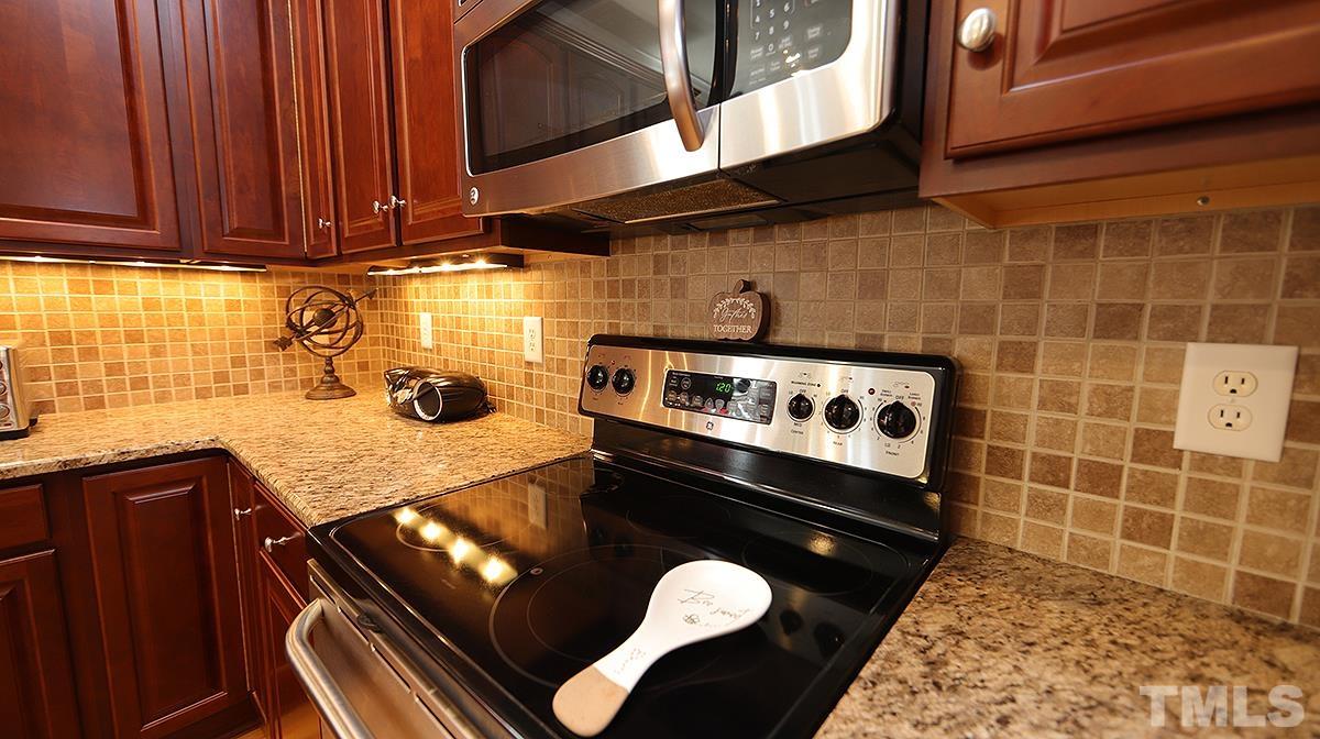 152 Rivers Edge Court Timberlake, NC 27583 - Photo 15 of 41 a kitchen with a stove a microwave a sink and cabinets