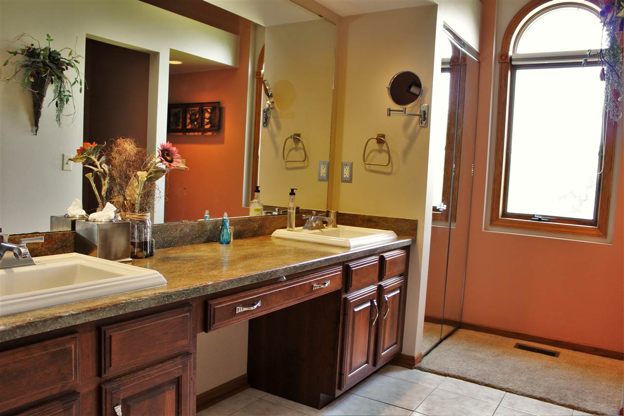 766 Timber Ridge Trail Rockford, IL 61114 - Photo 13 of 25 a bathroom with a granite countertop sink a mirror and a shower