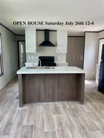 a view of kitchen with stainless steel appliances cabinets and wooden floor