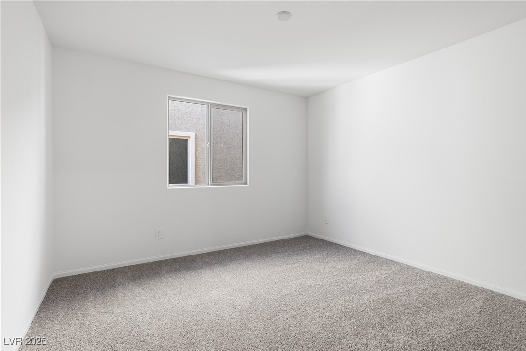 5670 Spring Trellis Street Las Vegas, NV 89113 - Photo 9 of 23 Spare room with light colored carpet and baseboards