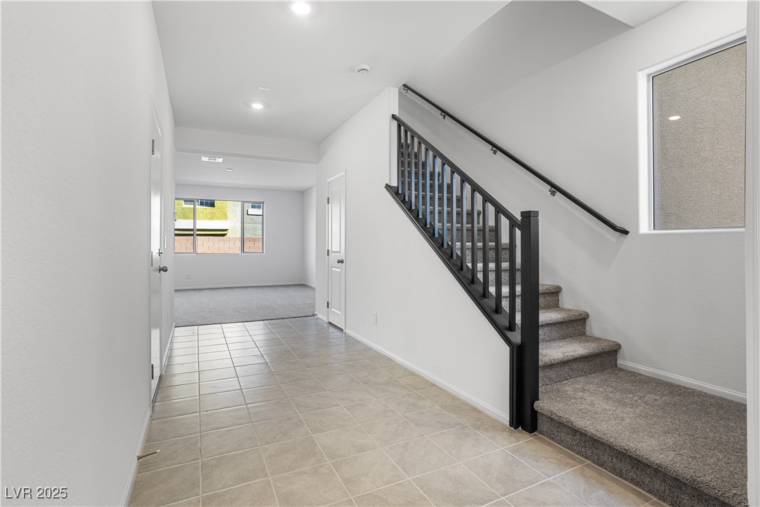 5670 Spring Trellis Street Las Vegas, NV 89113 - Photo 2 of 23 Stairway with tile patterned flooring and carpet floors