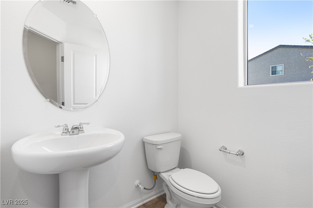 5670 Spring Trellis Street Las Vegas, NV 89113 - Photo 4 of 23 Half bathroom with toilet and baseboards