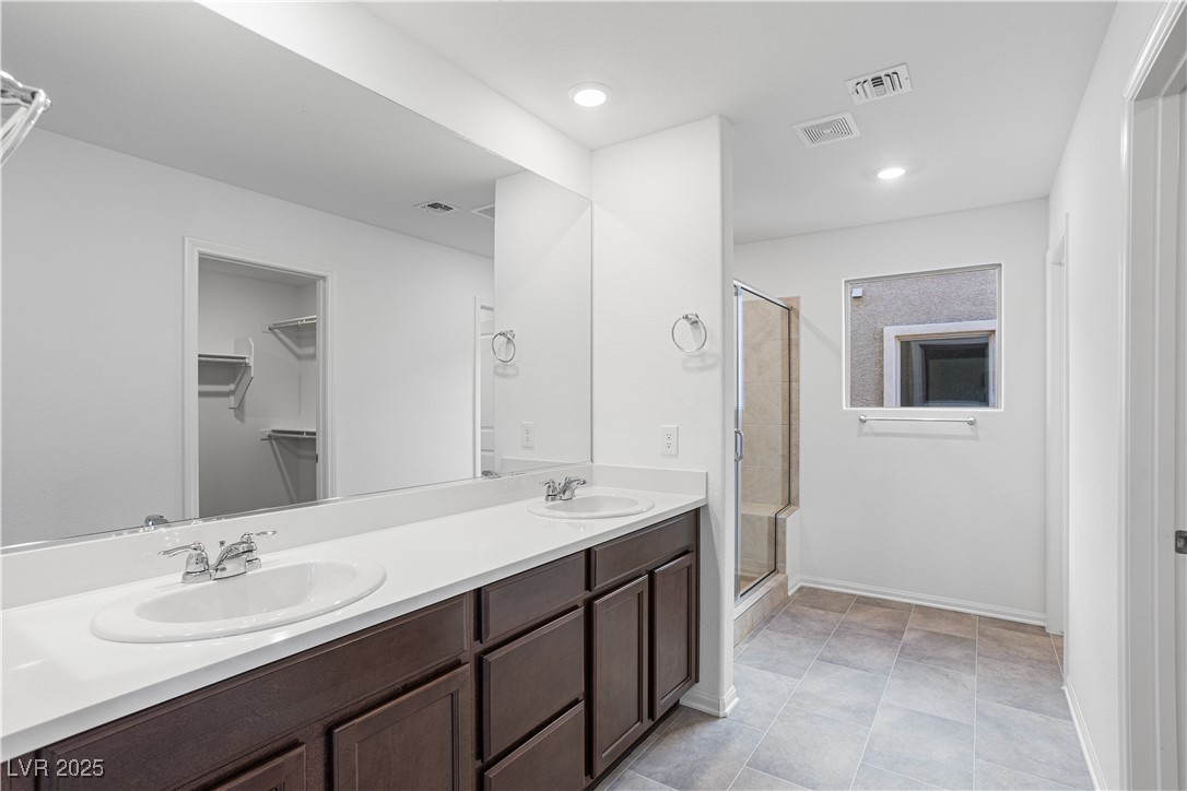 5670 Spring Trellis Street Las Vegas, NV 89113 - Photo 6 of 23 Full bath featuring a spacious closet, a shower stall, double vanity, recessed lighting, and light tile patterned floors