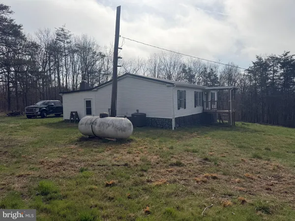 a backyard of a house with barbeque oven and trees