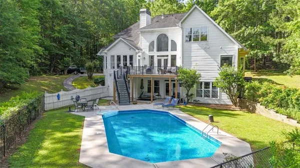 a view of a house with swimming pool and sitting area