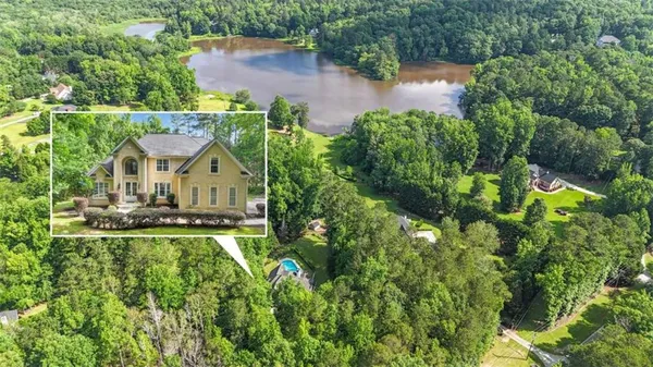 an aerial view of residential house with outdoor space and trees around