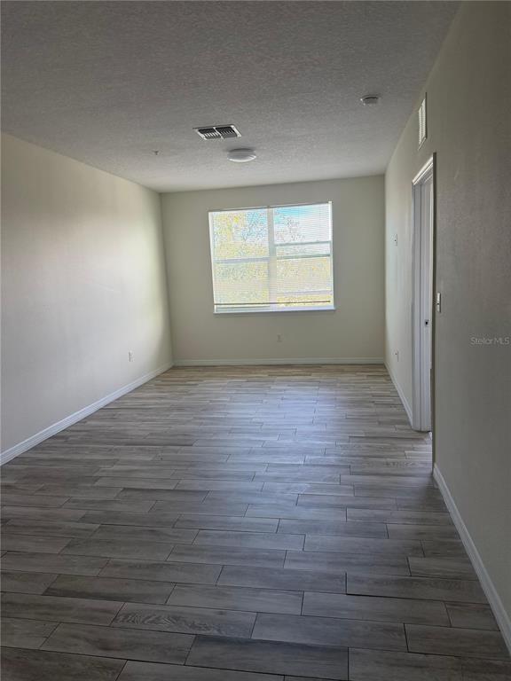 2121 McCoy Road, Unit 235 Orlando, FL 32809 - Photo 14 of 20 wooden floor in an empty room with a window