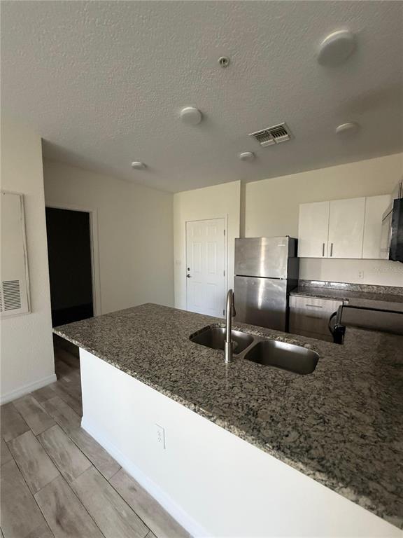 2121 McCoy Road, Unit 235 Orlando, FL 32809 - Photo 5 of 20 a kitchen with kitchen island granite countertop a sink a counter and stainless steel appliances