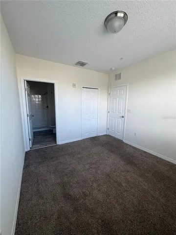 an empty room with windows and closet