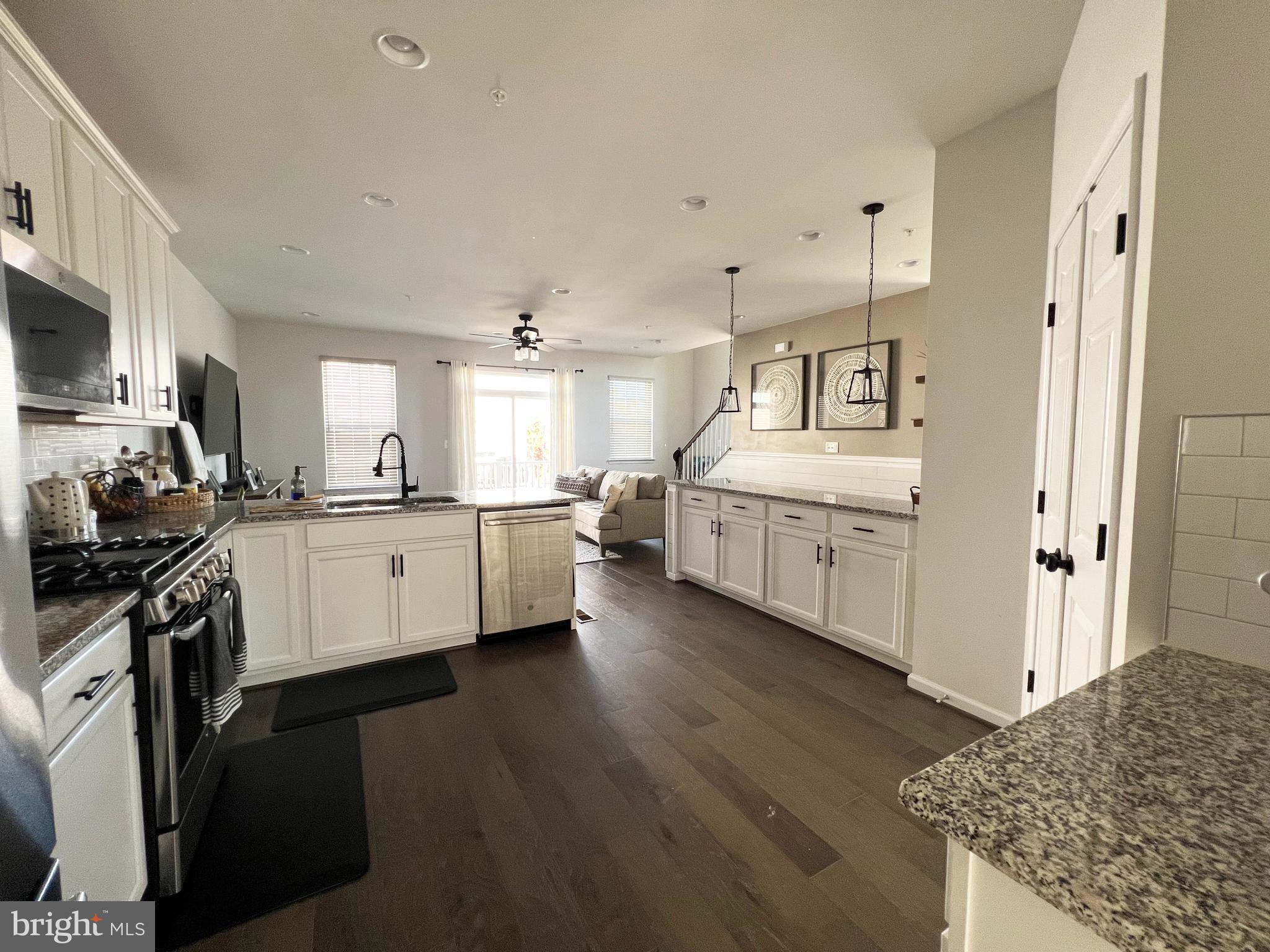 3501 Landing Way Silver Spring, MD 20906 - Photo 11 of 42 a large white kitchen with a stove top oven a sink dishwasher and a refrigerator with wooden floor