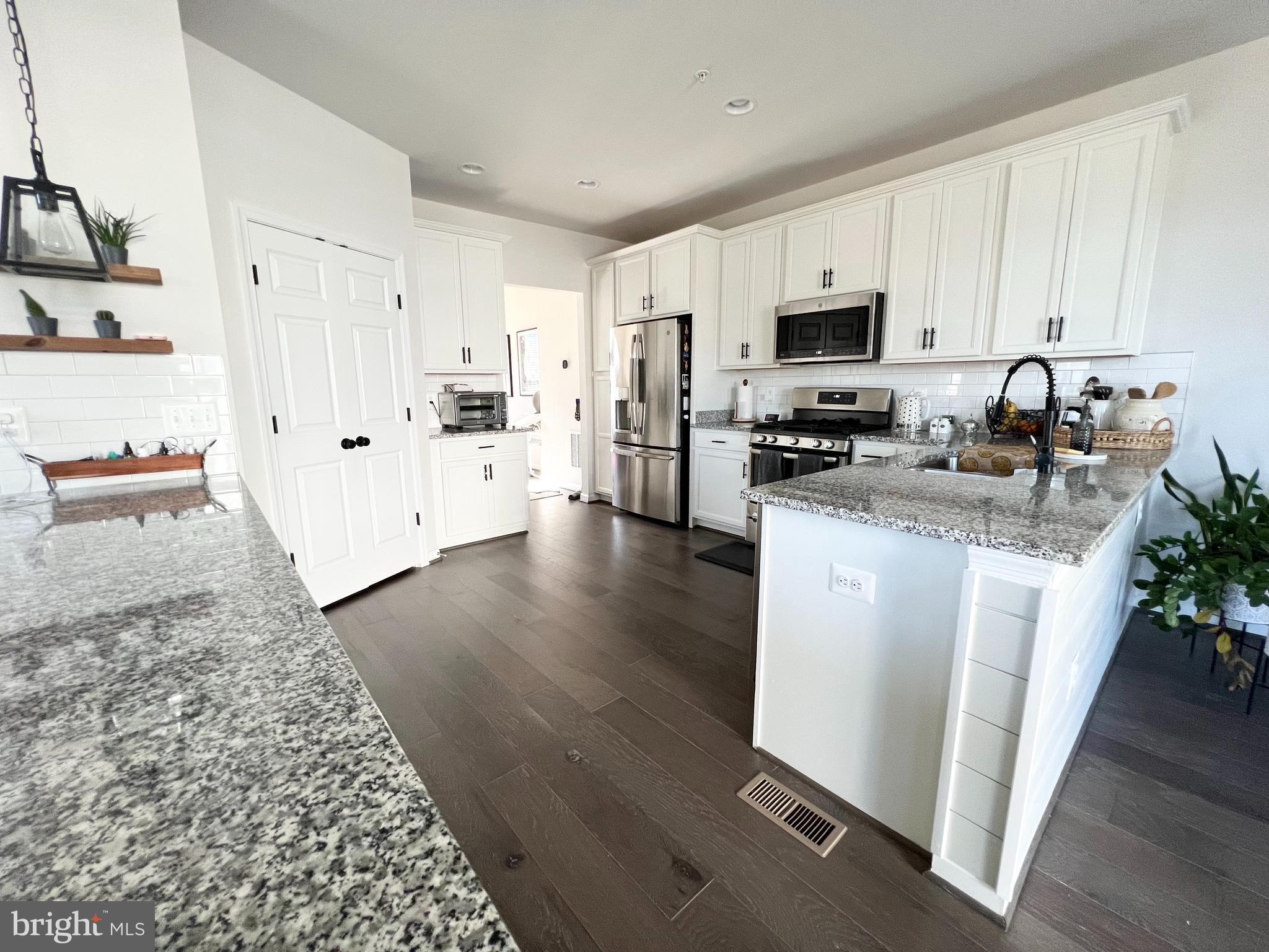 3501 Landing Way Silver Spring, MD 20906 - Photo 10 of 42 a kitchen with stainless steel appliances granite countertop a stove top oven a sink a refrigerator white cabinets and wooden floor