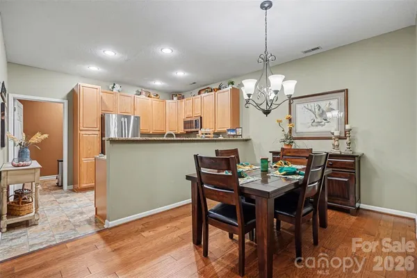 a dining room filled chandelier and wooden floor