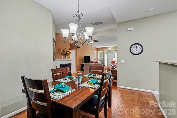 a view of a dining room with furniture a chandelier and wooden floor