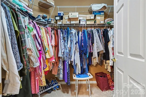 a view of walk in closet with clothes