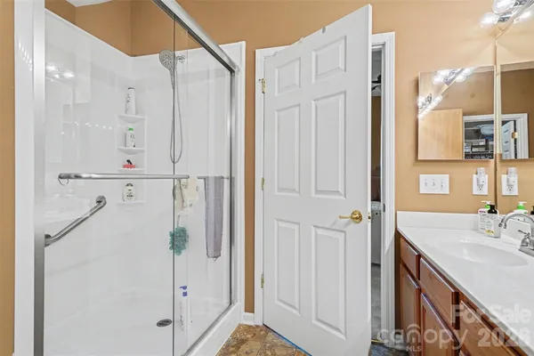 a bathroom with a shower sink and mirror