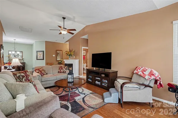 a living room with furniture a flat screen tv and a window
