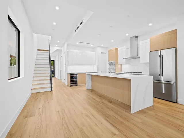 a kitchen with stainless steel appliances granite countertop a refrigerator and a stove top oven