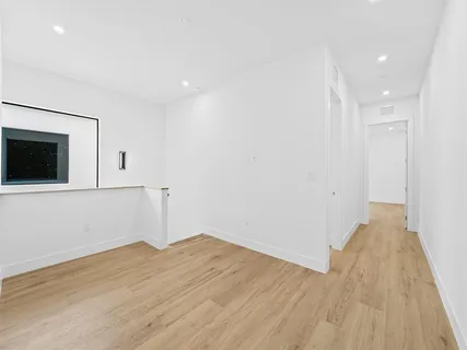 a view of a room with wooden floor and brick wall