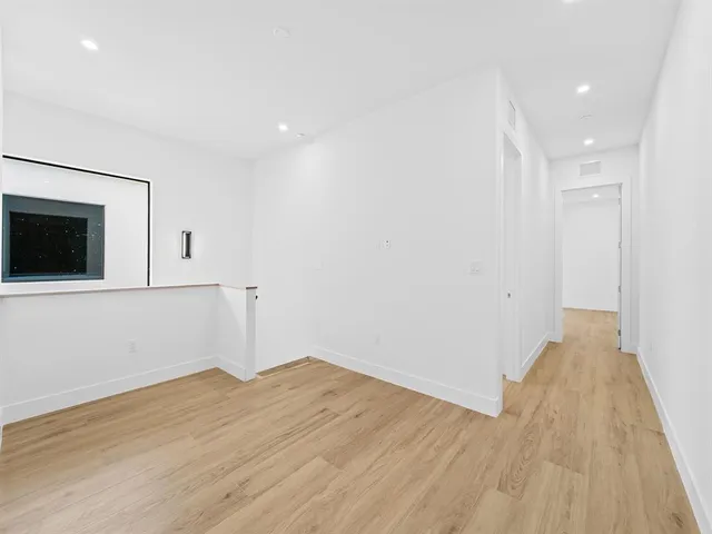 a view of a room with wooden floor and brick wall