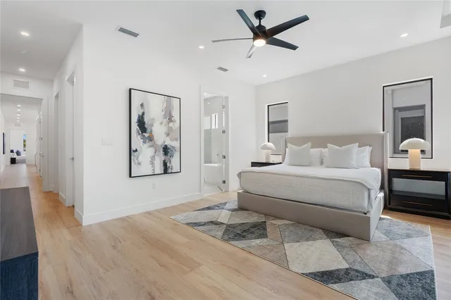 a bedroom with a large bed and a chandelier