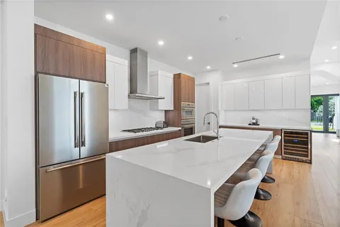 a kitchen with kitchen island white cabinets and stainless steel appliances