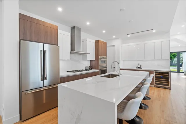 a kitchen with kitchen island white cabinets and stainless steel appliances