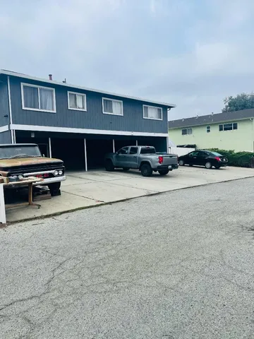 a view of garage with a car parked beside it
