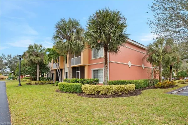 a view of a white house with a big yard and palm trees