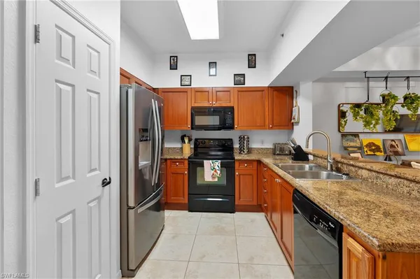 a large kitchen with stainless steel appliances granite countertop a stove refrigerator and a sink