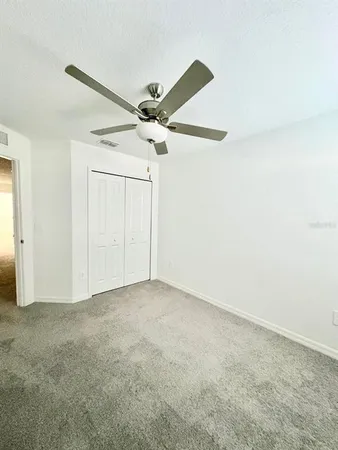 an empty room with a ceiling fan and a window