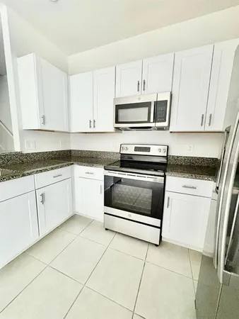 a kitchen with cabinets stainless steel appliances and sink