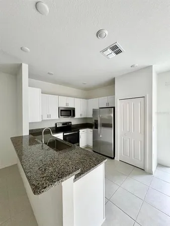 a kitchen with stainless steel appliances granite countertop a sink refrigerator and microwave