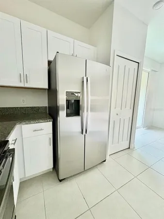 a white refrigerator freezer and a stove sitting inside of a kitchen