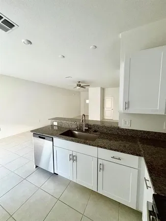 a kitchen with granite countertop a sink and a stove