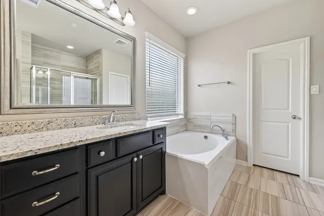 a bathroom with a sink a mirror and a bathtub