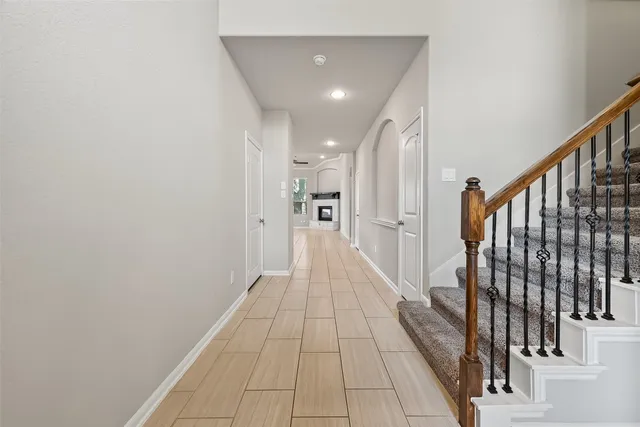 a view of a hallway with wooden floor and staircase