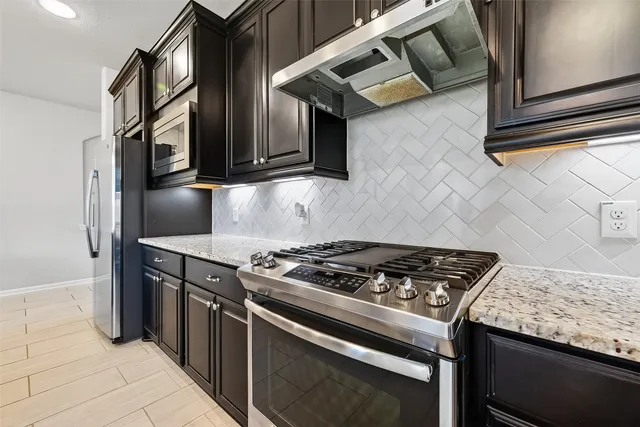 a kitchen with stainless steel appliances granite countertop a stove and a microwave